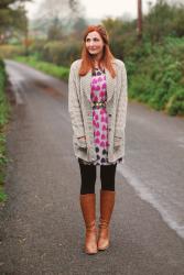 Cable Knit Cardigan Layered Over A Patterned Dress