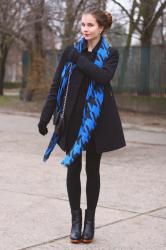 Czarny płaszcz, czarna sukienka i niebieski szal