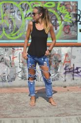 Jeans strappati e una canotta nera 