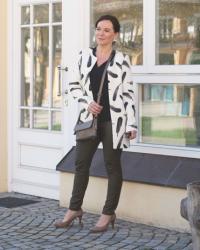 Spring look in a printed coat and leather leggings