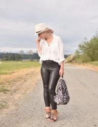 It's black and white:  styling vegan leather leggings with an oversized shirt, straw fedora, and beaded sandals