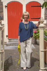 Pebble coloured trousers with a colourful necklace