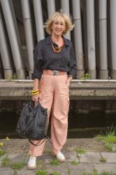 Pink cargo trousers with a black linen shirt