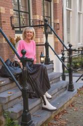 Black pleated skirt with a pink jumper