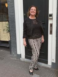 White trousers with a bright blue top and pearls