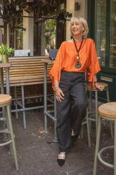 Black linen trousers with an orange top